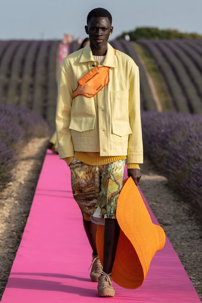 Trang phục cho phái mạnh cũng cầu kỳ không kém. Loạt người mẫu nam mặc quần bermuda, áo sơ mi, áo khoác chất khaki có màu trung tính như xám, beige hòa trộn cùng những tông sặc sỡ của mùa hè như vàng nghệ, nâu đất, cam neon.