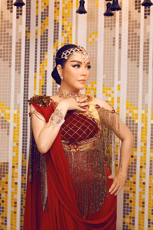 Lý Nhã Kỳ diện chiếc đầm haute couture màu đỏ đậm được đo may riêng cho cô. NTK Ấn Độ đã khéo léo may những đường chỉ vàng tua rua, cộng với vàng lá lấp lánh đính trên vai.