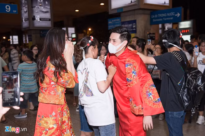 Đông đảo người hâm mộ đến đón 2 ca sĩ. Họ mang theo lễ phục màu đỏ, mâm quả cưới, hoa, bánh kem để gây bất ngờ cho thần tượng.