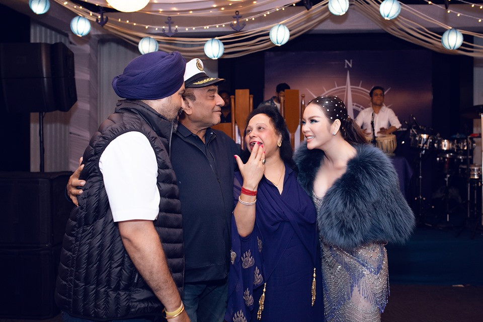 Nữ diễn viên được bố mẹ nuôi đưa đi giới thiệu với các khách mời trong đêm tiệc.