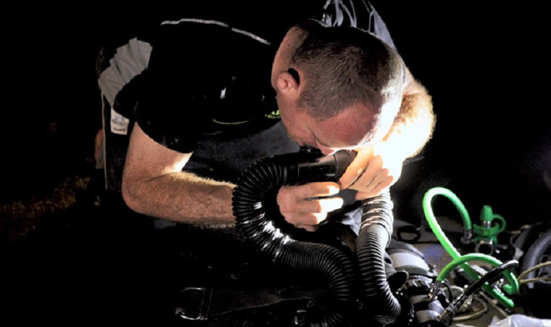 Một chuyên gia đang kiểm tra lại máy móc trước khi lặn xuống thám hiểm dòng sông ngầm khổng lồ dưới hang Sơn Đoòng. (Ảnh: Thanh Niên)