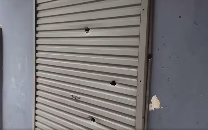 Tại hiện trường, những phát đạn đã làm thủng nhiều lớp cửa, xuyên thủng đầu xe máy, để lại chi chít lỗ trên tường trong nhà.