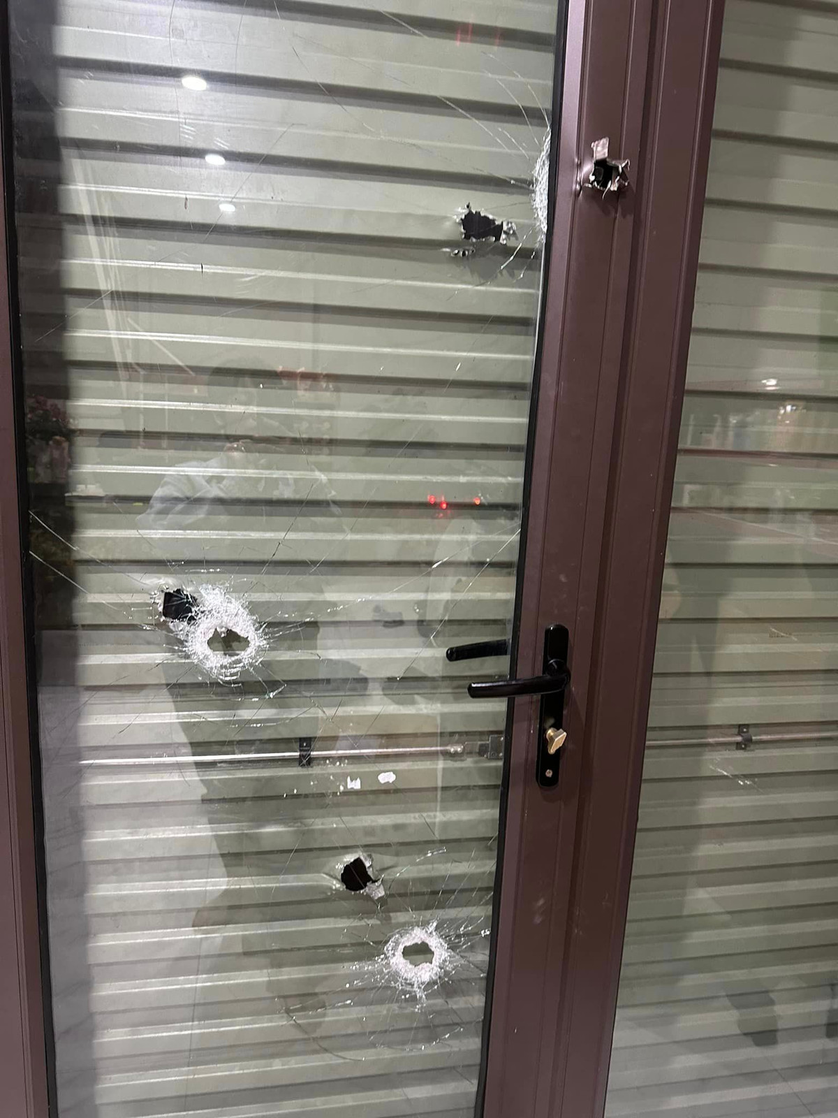 “Khi các cháu lên gác ngủ, các đối tượng đã nổ súng bắn trực tiếp vào cửa nhà qua một lớp cửa cuốn, một lớp kính và găm vào tường và xe máy để trong nhà”, bà T. nói. 