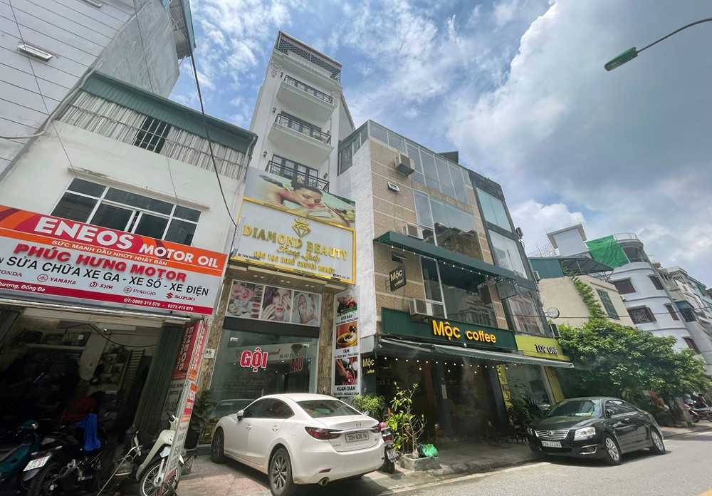 Những căn nhà méo mó, “biến” phần mái thành tầng không khó bắt gặp trên con phố Tam Khương. Chẳng hạn, căn nhà số 98 Tam Khương có tầng 1 sử dụng làm quán sửa chữa xe máy, còn phần mái được gia chủ lắp khung thép, quây mái tôn thành tầng lửng.