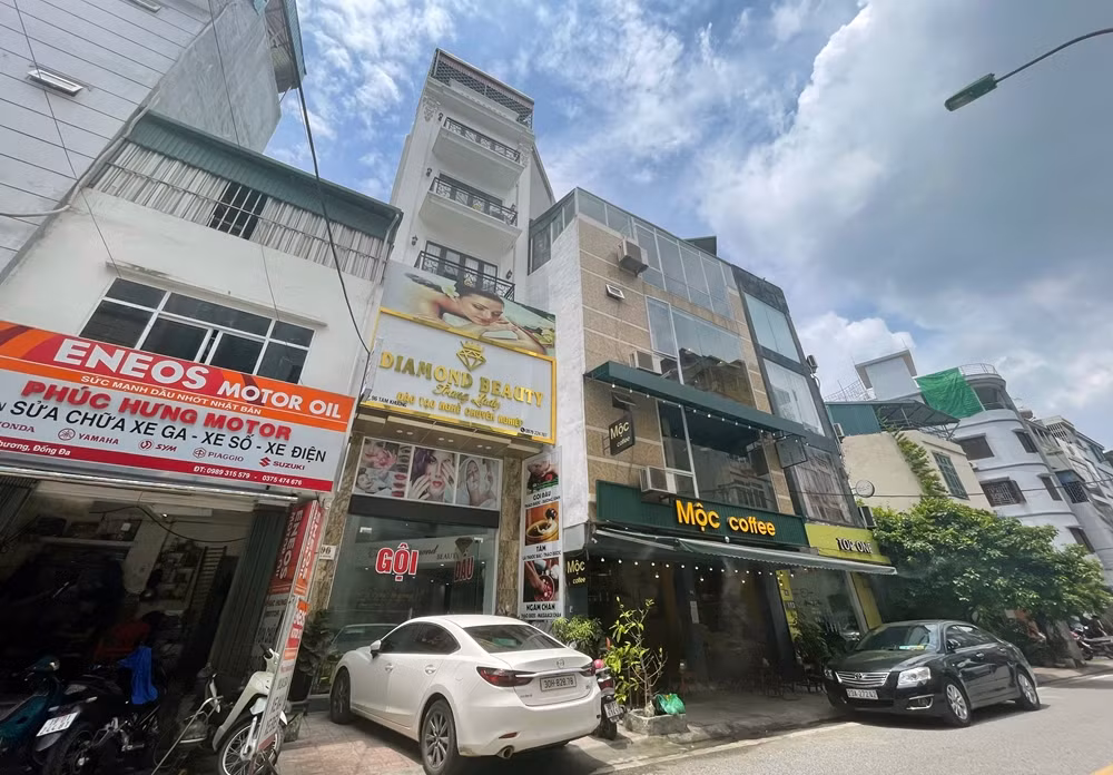 Những căn nhà méo mó, “biến” phần mái thành tầng không khó bắt gặp trên con phố Tam Khương. Chẳng hạn, căn nhà số 98 Tam Khương có tầng 1 sử dụng làm quán sửa chữa xe máy, còn phần mái được gia chủ lắp khung thép, quây mái tôn thành tầng lửng.