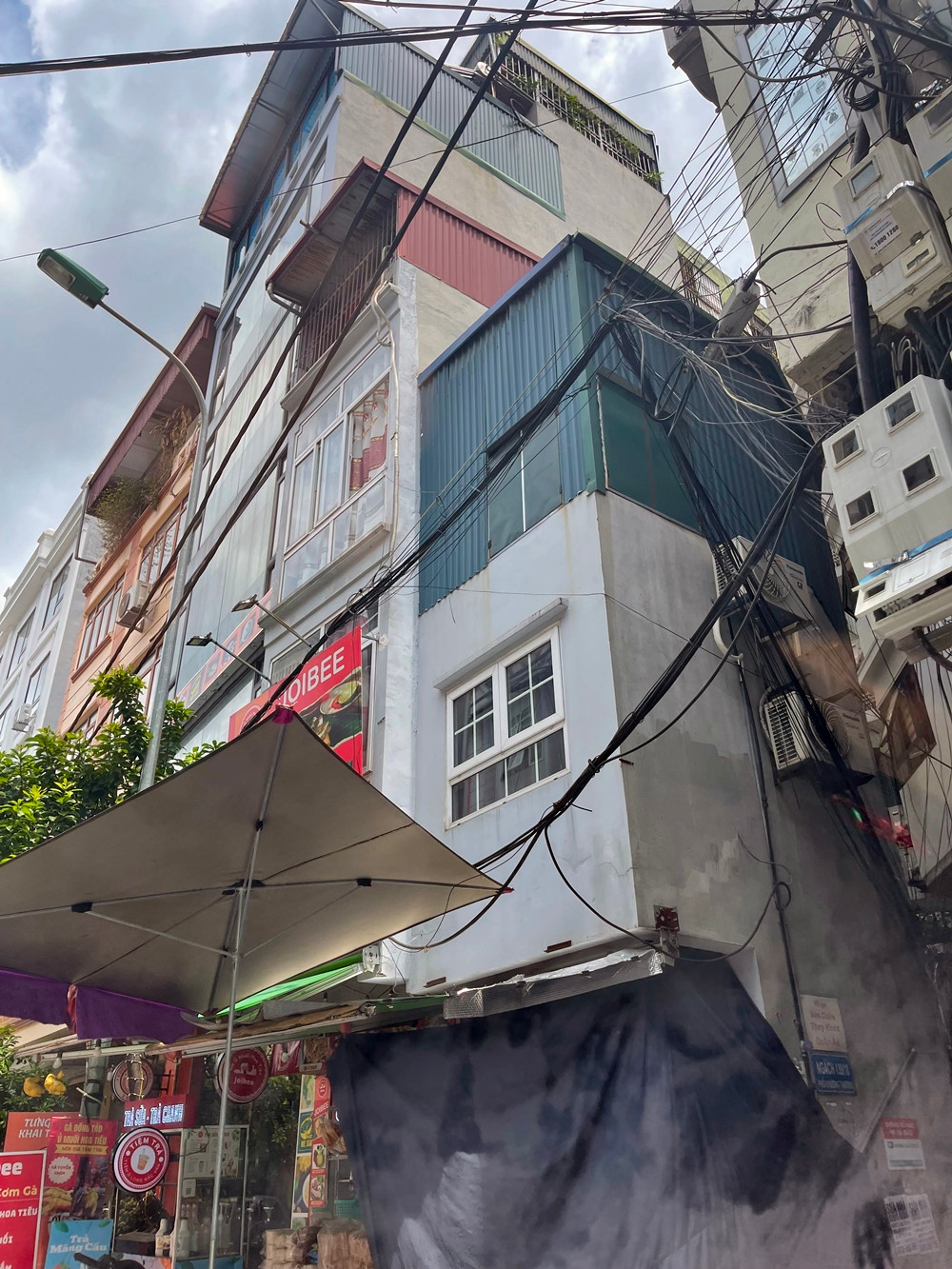 Một căn nhà khác nằm "thọt lỏm" giữa các căn bên cạnh. Căn nhà này "nâng tầng" bằng cách quây tôn lùm xụp ở phần mái trông nhếch nhác mất mỹ quan.