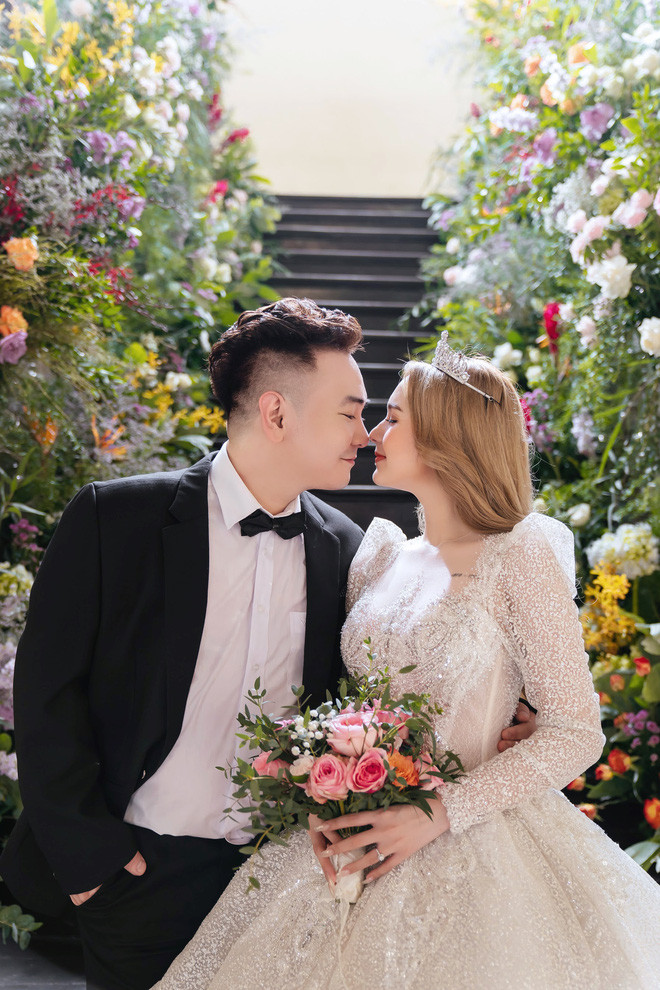 Váy cưới của cô dâu Phạm Trang được lấy ý tưởng từ chiếc váy của nữ hoàng Ravenna. Chiếc váy còn được đính kết theo họa tiết hoàng gia, kết hợp 30.000 viên đá Swarovski ánh bạc và pha lê ánh trắng cực sang.