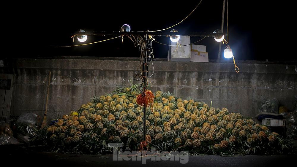 Chủ yếu hoạt động về đêm và rạng sáng, chợ không chỉ phục vụ những người đến mua buôn mà còn bán lẻ để phục vụ nhu cầu của người dân. Ảnh: Hoa quả sau khi nhận từ xe của các cửu vạn được đổ thành đống để tiểu thương dễ dàng lựa chọn. 