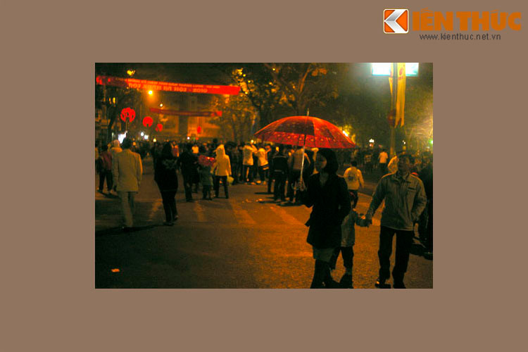 Người dân đón Giao thừa ở bờ hồ Hoàn Kiếm trong mưa phùn, tiết trời đặc trưng của Hà Nội ngày Tết, 23h33.