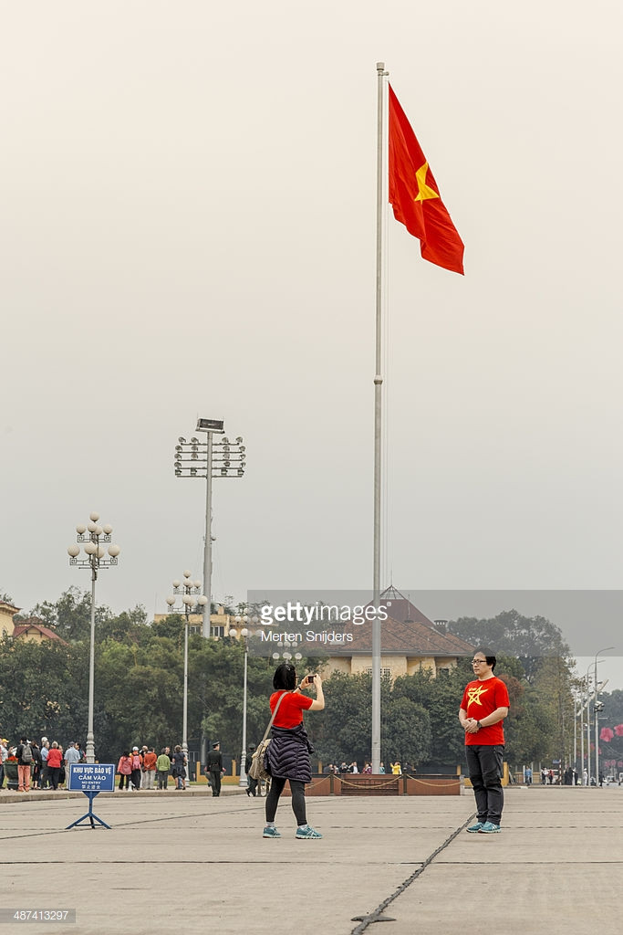 Du khách nước ngoài chụp ảnh lưu niệm trước cột cờ Quảng trường Ba Đình. Ảnh: Merten Snijders/ Getty.