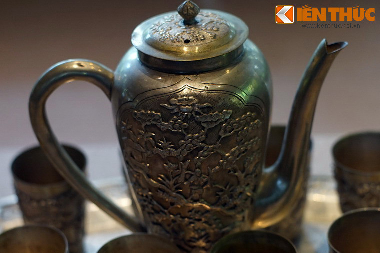 Cận cảnh họa tiết trang trí trên chiếc ấm với hình tiều phu gánh củi trong rừng.