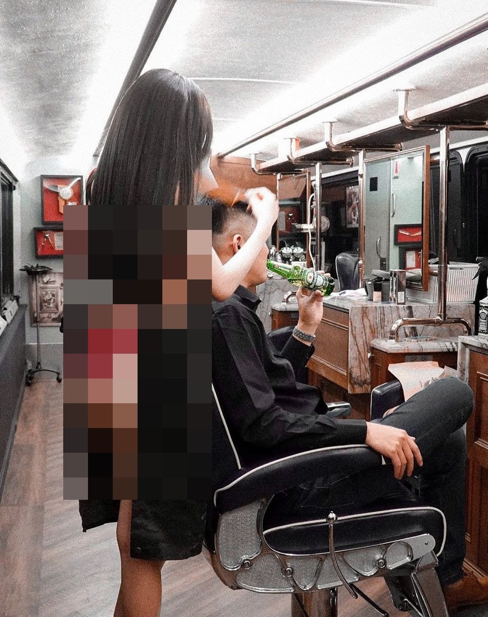 Vài ngày trước, hot girl gợi cảm đăng ảnh cô đứng cắt tóc cho một khách hàng nam. Đáng nói, trong lúc hành nghề, cô nàng chỉ mặc đúng một bộ nội y bằng ren màu đỏ và tròng qua cổ chiếc tạp dề đen.