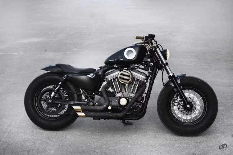 Cả 2 bánh của xe đều sử dụng vành nan đi kèm với lốp vintage Firestone. Dè trước được cắt gọn, cùng với sự "thiếu vắng" của bảng đồng hồ càng khiến chiếc xe trở nên đơn giản hơn.