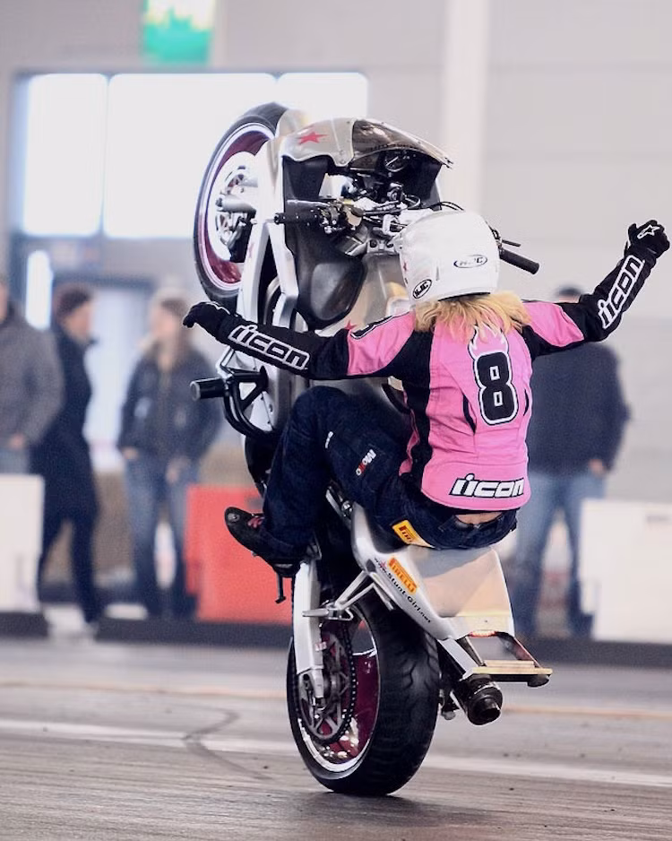 Một nữ stunter chuyên nghiệp đang thi đấu tại châu Âu "bốc đầu" với hai tay thả ra khỏi ghi-đông.