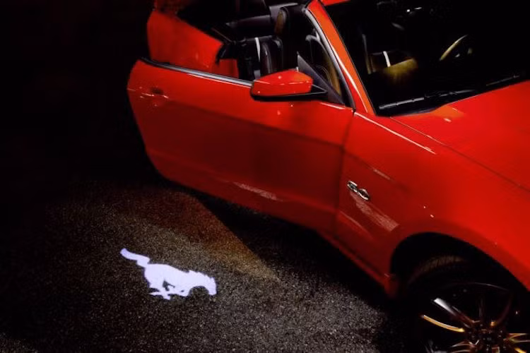 Đèn soi cửa của Ford Mustang: Có hình dáng logo ngựa của dòng xe Mustang, tùy chọn này chỉ giúp chiếu xuống nền đất logo của xe.