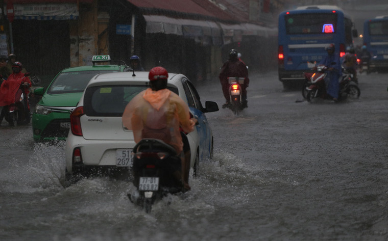 Tại nhiều tuyến đường, mưa to nước chảy xiết thành dòng xô ngã hàng loạt người đi đường. 
