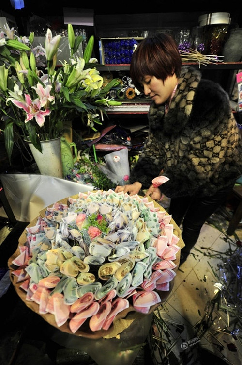 Theo Sina, trong dịp Valentine vừa qua, một chàng trai đã đặt làm bó hoa với tổng số tiền sử dụng lên đến gần 7 nghìn tệ, tương đương hơn 24 triệu đồng. Trước khi đến đặt làm hoa, chàng trai này cũng phải vất vả đến một vài ngân hàng để đổi cho được các xấp tiền 100 tệ đến 20 tệ.