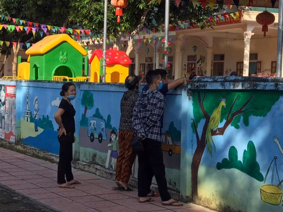 Mặc dù đã trao con tận tay cho cô giáo nhưng các bậc cha mẹ vẫn không yên tâm và ở lại theo dõi tình hình của con. Ảnh: Thúy Mit