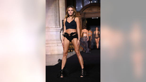Người mẫu 20 tuổi trình diễn bộ nội y nóng bỏng màu đen, đi kèm đôi giày cao gót cùng màu đính lông vũ.