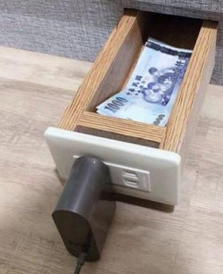 Theo lời kể của cô vợ, một lần nọ, khi đang tìm ổ điện để sạc điện thoại, và rồi khi kiểm tra, cô phát hiện, đó không phải là một chiếc ổ điện thông thường mà đó chỉ là một cách để ngụy trang cho hành động giấu quỹ đen của chồng mình. Bên trong chiếc ổ điện là một ngăn kéo có rất nhiều tiền.