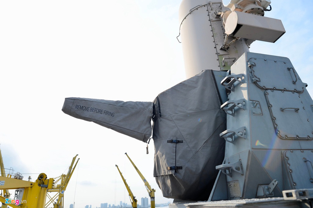 Một nòng pháo được phủ bạt với dòng chữ "gỡ (bạt) trước khi bắn". Hệ thống phòng thủ tầm cực gần (CIWS) Phalanx với pháo 20 mm 6 nòng. Pháo có tốc độ bắn tới 5.000 viên trên phút, được sử dụng cho nhiệm vụ đánh chặn tên lửa và vũ khí dẫn đường của đối phương.