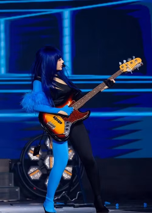 Hình ảnh Huyền Baby chơi guitar bass.