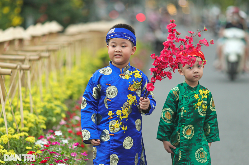 Hai anh em Gia Thành và Hoàng Bách được bà của mình chuẩn bị áo dài, cành đào để tới chụp hình tại địa điểm "được săn tìm" những ngày qua.