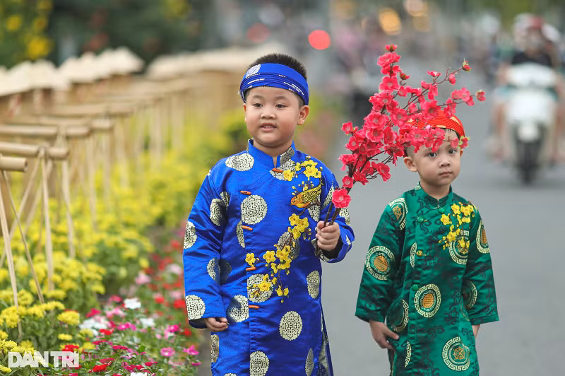 Hai anh em Gia Thành và Hoàng Bách được bà của mình chuẩn bị áo dài, cành đào để tới chụp hình tại địa điểm "được săn tìm" những ngày qua.