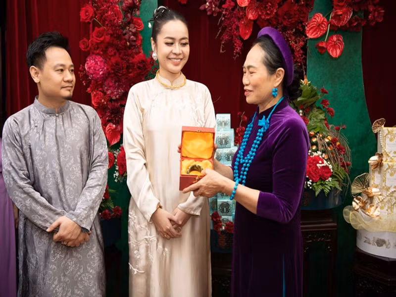 Theo Vietnamnet, Vũ Hạnh Nguyên nhận nhiều vàng trong lễ ăn hỏi. Trong ảnh, cô được mẹ ruột tặng chiếc kiềng vàng 1,5 cây và vòng ngọc trị giá 20.000 USD (gần 500 triệu đồng). Ảnh: Vietnamnet.