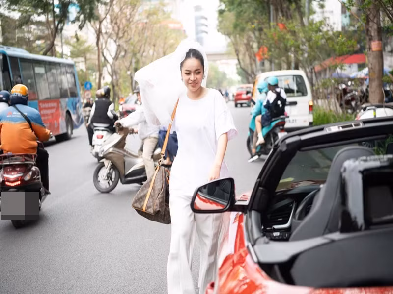 Sau khi hoàn tất các nghi thức của lễ ăn hỏi, Vũ Hạnh Nguyên thay trang phục, tự lái xe mui trần chở nhạc sĩ Nguyễn Đức Cường. Ảnh: Znews.