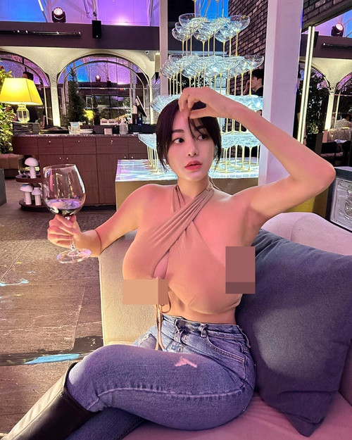 Ngoài mốt không nội y, hot girl xinh đẹp yêu thích mẫu áo cổ yếm với chi tiết cắt khoét để lộ chân ngực.