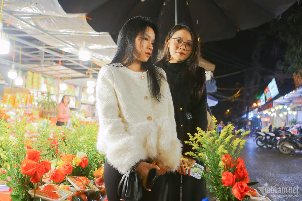 Nguyệt (áo đen) và Nga không ngại trời mưa rét để đi từ quận Nam Từ Liêm mất hơn chục kilomet có mặt tại phủ Tây Hồ đúng giờ. Hai bạn cho biết, có thói quen dâng lễ vào ngày mùng 1 âm lịch hàng tháng. "Em chỉ cầu cho bản thân và gia đình được mạnh khỏe và bình an", Nguyệt chia sẻ.