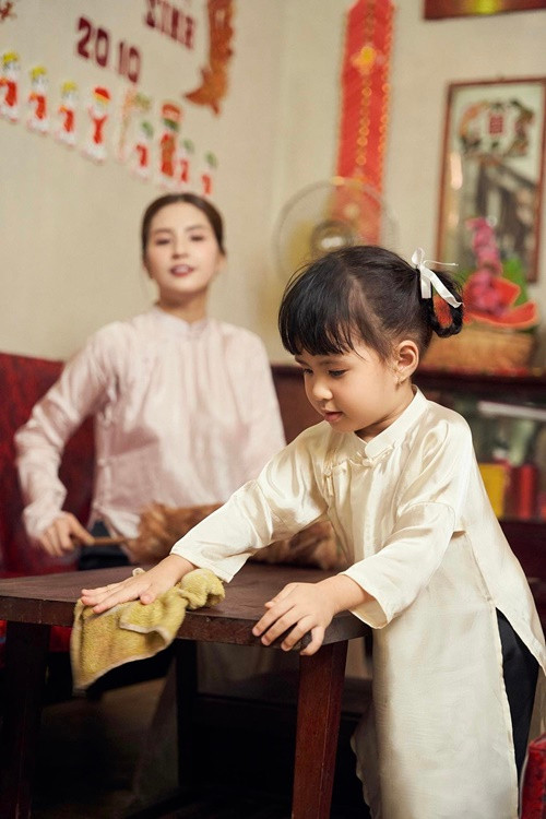 Cô nhóc cùng mẹ tạo dáng lau dọn nhà cửa.