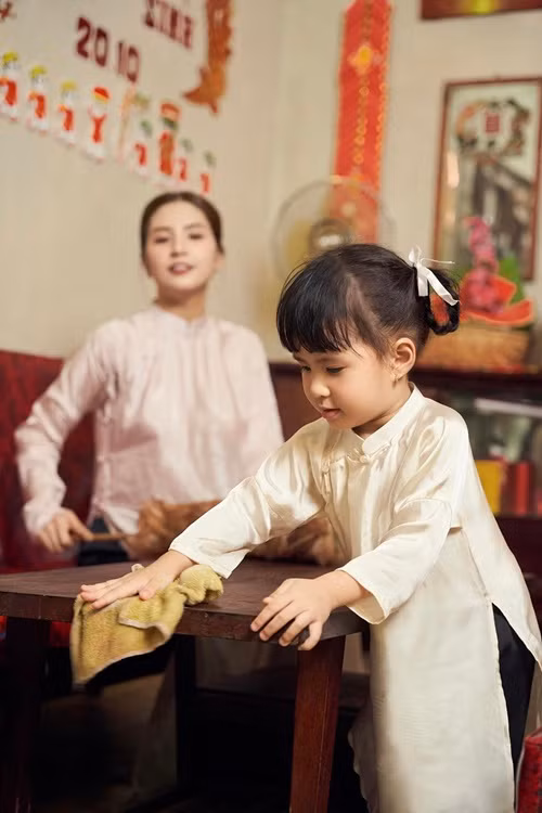 Cô nhóc cùng mẹ tạo dáng lau dọn nhà cửa.