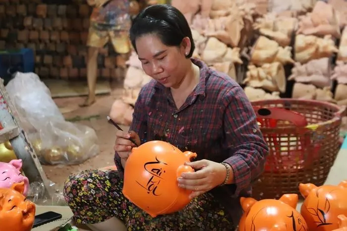 Sau khi sơn nền cho thân, người thợ sẽ vẽ chi tiết, tạo điểm nhấn như: khai nhãn, vẽ đuôi, trang trí nơ, hoa… Công đoạn vẽ đòi hỏi người thợ phải khéo léo, dồn tâm huyết qua từng nét cọ. Công đoạn này thường do phụ nữ đảm nhận. Với người thợ sơn sẽ được nhận thù lao từ 500 đồng đến 3.000 đồng/con; thợ vẽ có thù lao từ 30.000 đến 40.000 đồng/giờ; thợ bọc màng co từ 250.000 đến 300.000 ngày.