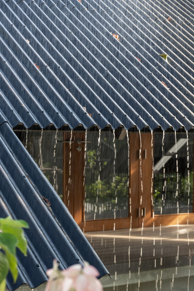 Mái nhà được thiết kế không có máng xối để nước đổ trực tiếp xuống đất, giữ lại mối quan hệ tự nhiên.