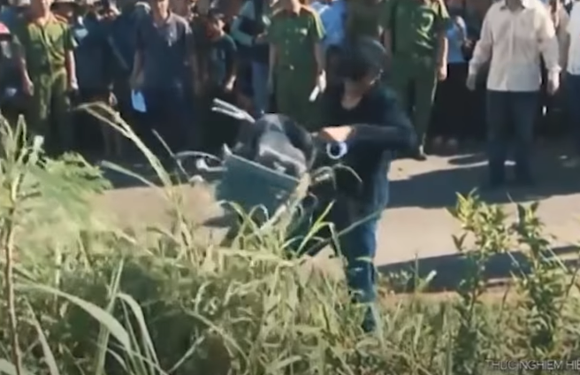 Thấy nạn nhân té ngã xuống đường, Thực lập tức xông đến dùng hai tay xốc nách cháu T. để kéo vào lô cà phê của ông Lăng Văn Trình thì phát hiện trong túi áo khoác của nạn nhân có một chiếc điện thoại di động nên lấy cất vào túi quần. Sau khi lấy điện thoại, Thực gọi Phóng đến phụ giúp khiêng cháu T. vào lô cà phê gần đó. Phóng ở lại còn Thực chạy ra đường nhặt cặp sách, giày dép, xe đạp của cháu T. vứt vào bụi cỏ ven đường.