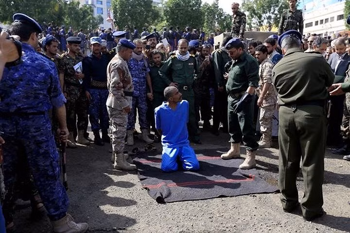 Ba tử tù là al-Ashhab (19 tuổi), al-'Uqri (27 tuổi), và Ghaleb al-Rashdi (19 tuổi). Họ (mặc áo tù nhân màu xanh) được dẫn giải ra quảng trường và được yêu cầu nằm lên một tấm thảm. Ảnh: Rex.