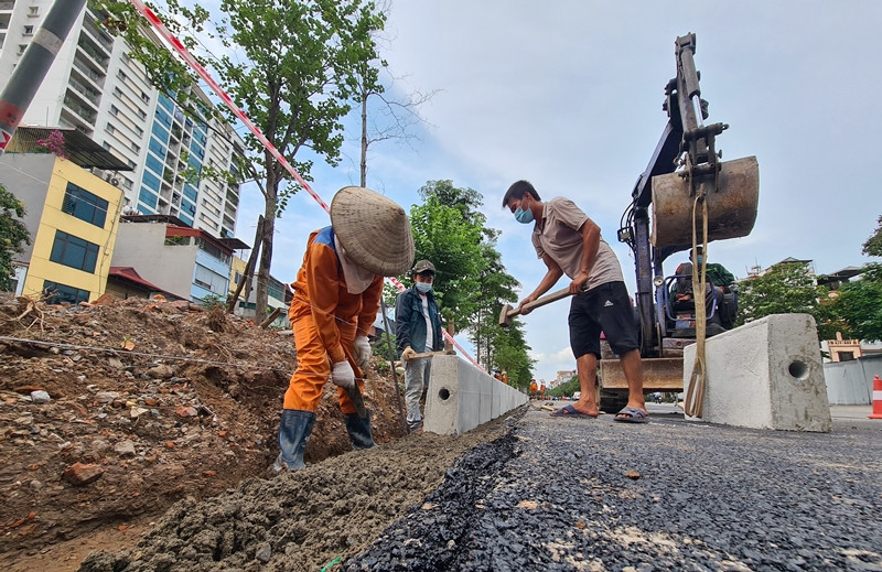 Nhà thi công đang hoàn thiện nốt dải phân cách giữa của tuyến đường sau khi được cắt xén.