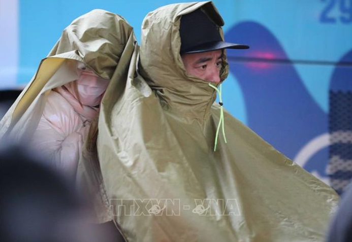 Người dân Hà Nội di chuyển trong mưa, rét. Ảnh: TTXVN