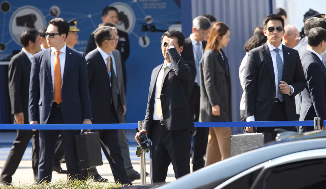 Trong các nhiệm vụ bảo vệ nguyên thủ khi di chuyển ở nơi công cộng, lực lượng cận vệ của Hàn Quốc thường rất dễ nhận ra với vẻ mặt khá "Lạnh" cùng kính râm và ống nhòm hoặc vali đựng súng trên tay. Nguồn ảnh: Chosun.