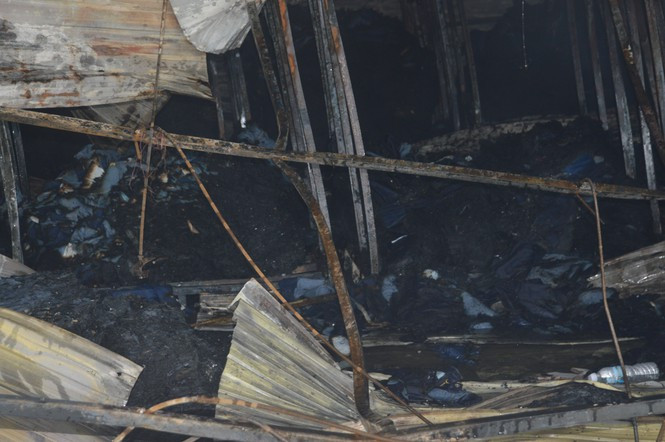 Hàng hoá thành tro. Lực lượng Cảnh sát cơ động phong tỏa bảo vệ hiện trường để phục vụ cho công tác khám nghiệm điều tra nguyên nhân vụ cháy.