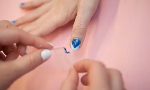 6. Móng đẹp với hai màu sơn: Để cho bộ móng trở nên thú vị hơn, bạn có thể vẽ móng hai màu. Sau khi đã chọn được hai tone màu đối lập, bạn sơn màu sáng hơn lên tất cả các ngón tay rồi đợi khô. Tiếp đó, lấy băng dính dán chéo phần trên móng để tạo nên một giao điểm chính giữa đầu móng. Sơn nốt màu còn lại cho toàn bộ móng. Sau khi sơn khô, bạn bóc dần băng dính ra và chiêm ngưỡng bộ móng mới. Ảnh: Cosmopolitan.