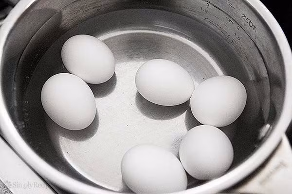 Dùng nước lạnh làm nguội trứng luộc: Trứng vừa luộc chín ngâm vào nước lạnh sẽ dễ bóc vỏ hơn. Việc làm này khiến cho vỏ trứng và phần lòng trắng sẽ co lại do gặp lạnh, tạo thành khe hở. Tuy nhiên, bạn không nên áp dụng cách làm thiếu khoa học này vì nước lã chứa lượng lớn vi khuẩn. Trứng gà sau khi đã luộc chín thì vỏ trứng không còn tác dụng ngăn chặn vi khuẩn. Ảnh: Simplyrecipes.