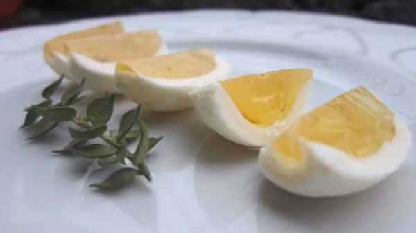 Kẹo cau: Đây là một thứ kẹo bình dân dành cho trẻ con, trông như miếng cau chẻ sáu, gồm có phần trong cứng màu vàng nhạt, tượng trưng cho hạt cau, là một phiến nước đường vàng óng; phần ngoài màu trắng, là thịt cau, làm bằng bột trộn đường. Đây là một món ăn dân dã khá lâu đời ở Huế, kẹo cau xưa thường được gói trong lá chuối khô nhưng giờ được làm thành miếng, gói trong giấy bóng kính sạch sẽ. Ảnh: iVIVU.