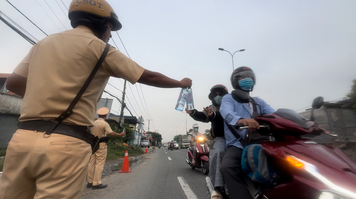 Người dân về quê các tỉnh Miền Tây nghỉ lễ Quốc khánh 2/9 được CSGT tặng nước suối để giải khát dọc đường.