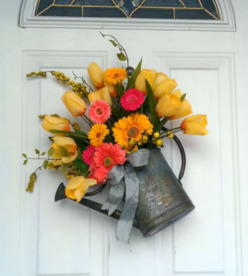 Tận dụng chiếc xô tưới nước làm chậu hoa treo trước cửa, tạo nên bức tranh mộc mạc.