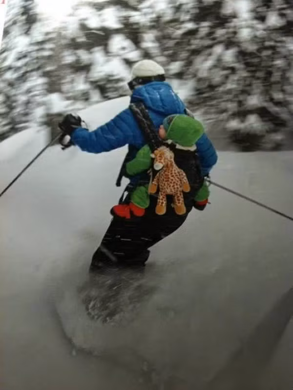  Vừa địu con vừa làm việc cũng chỉ thường thôi. Ông bố này còn phải tranh thủ trượt tuyết nữa.