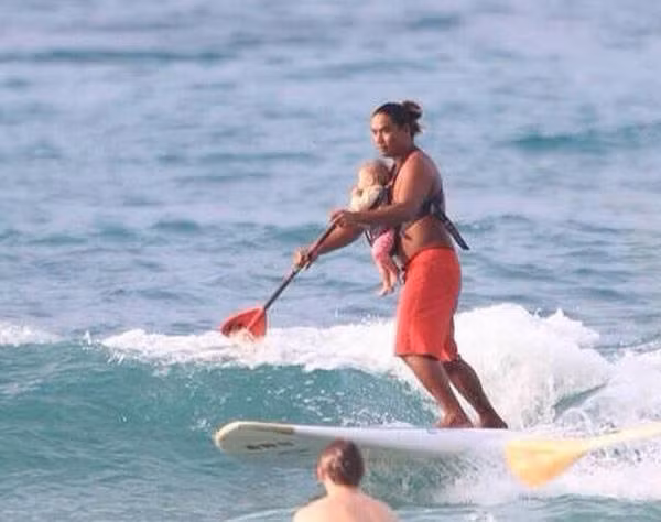 Ông bố này cho con cùng lướt sóng trên biển.