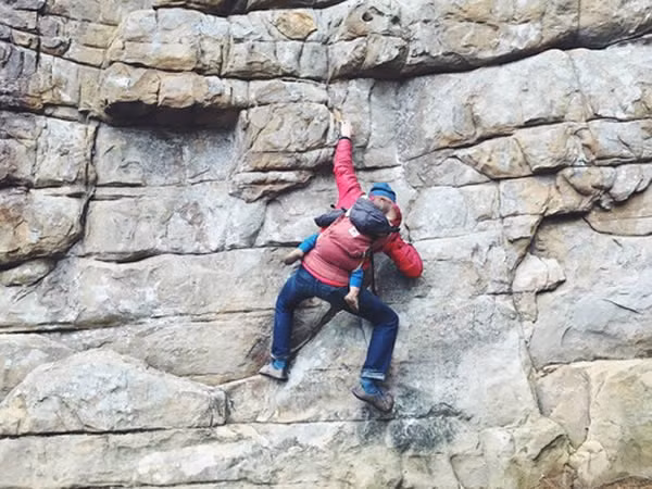 Thật mạo hiểm khi địu con sau lưng trong lúc trèo vách đá cheo leo như thế này.